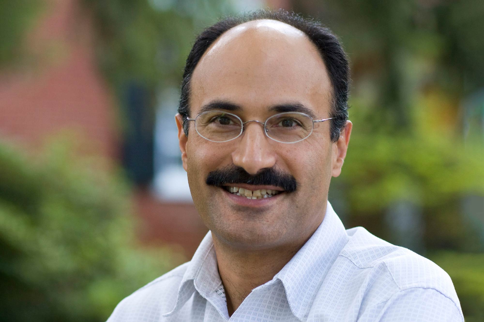 Jahan Ramazani is pictured in the center, a man with glasses and a mustache.