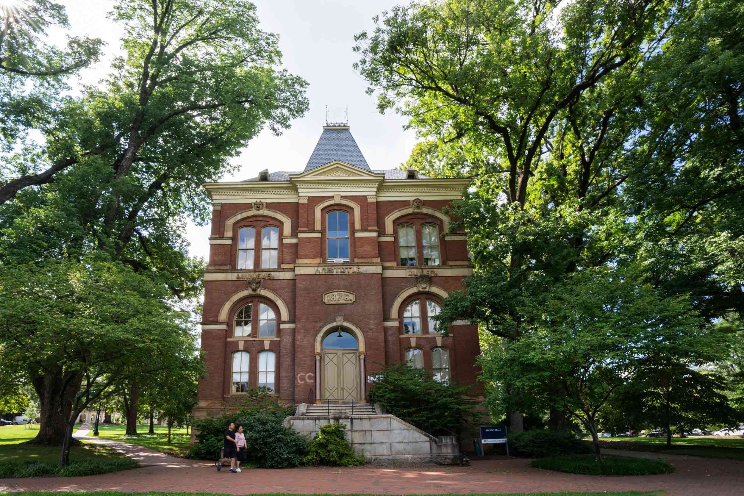 An image of historic brick Brooks hall, surrounded by trees
