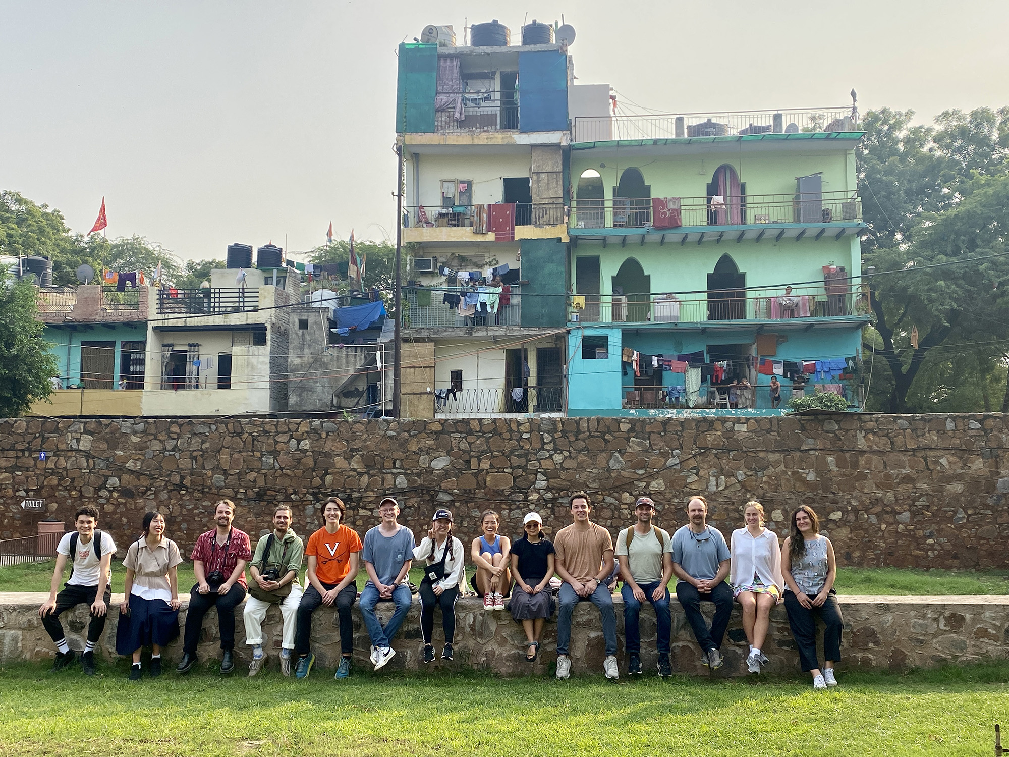 A group of students sit on a wall