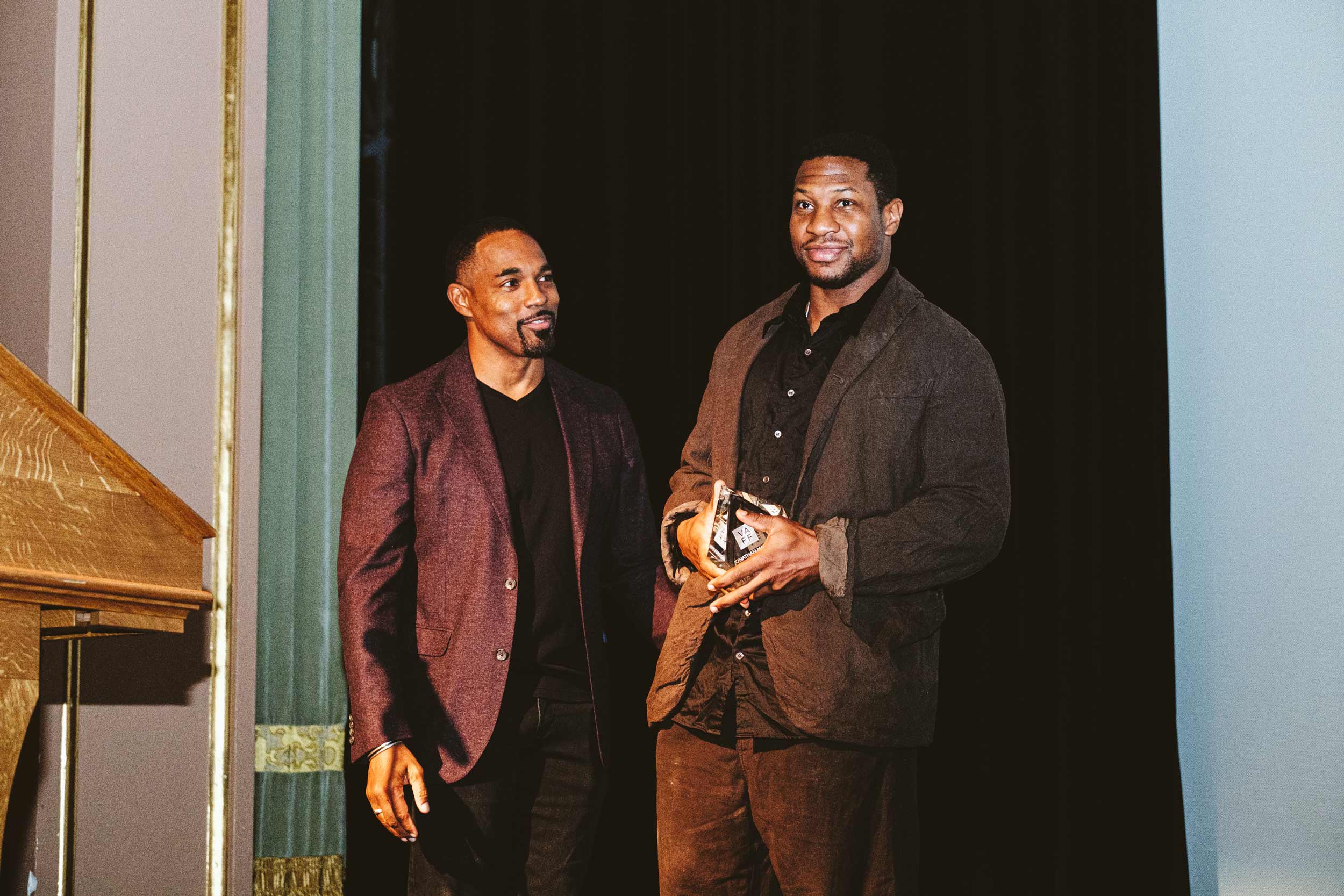 A photo of Jason George presenting an award to Jonathan Majors