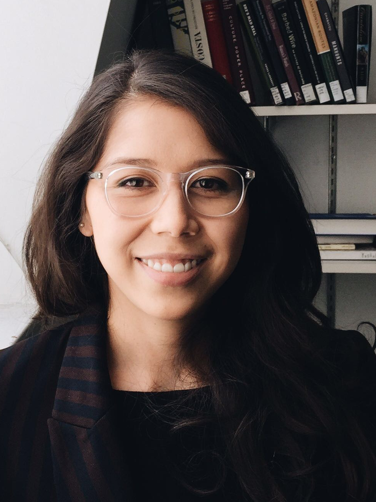 an image of Ana Ozaki standing in front of a bookshelf