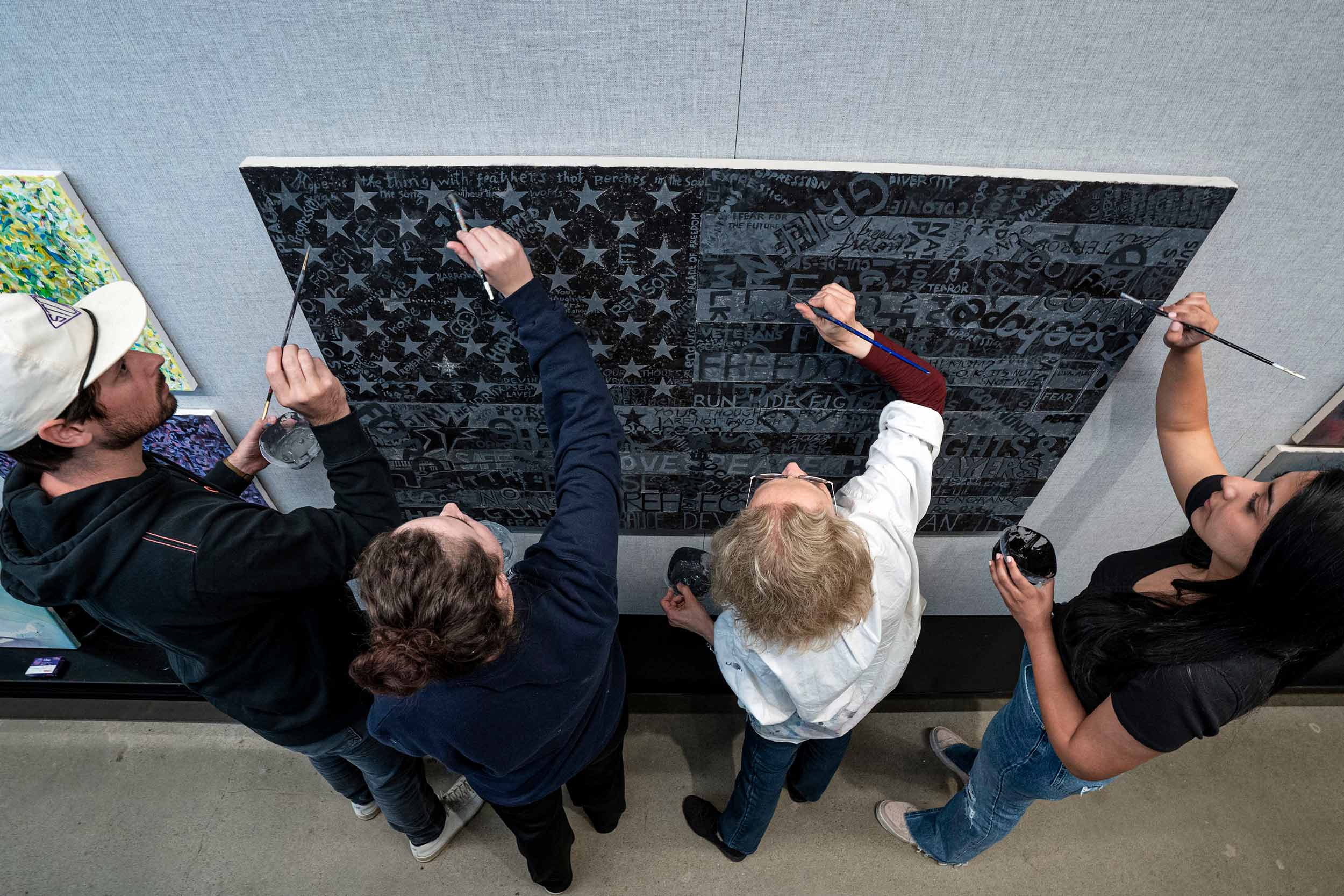 An image of people making art on a black and white American flag