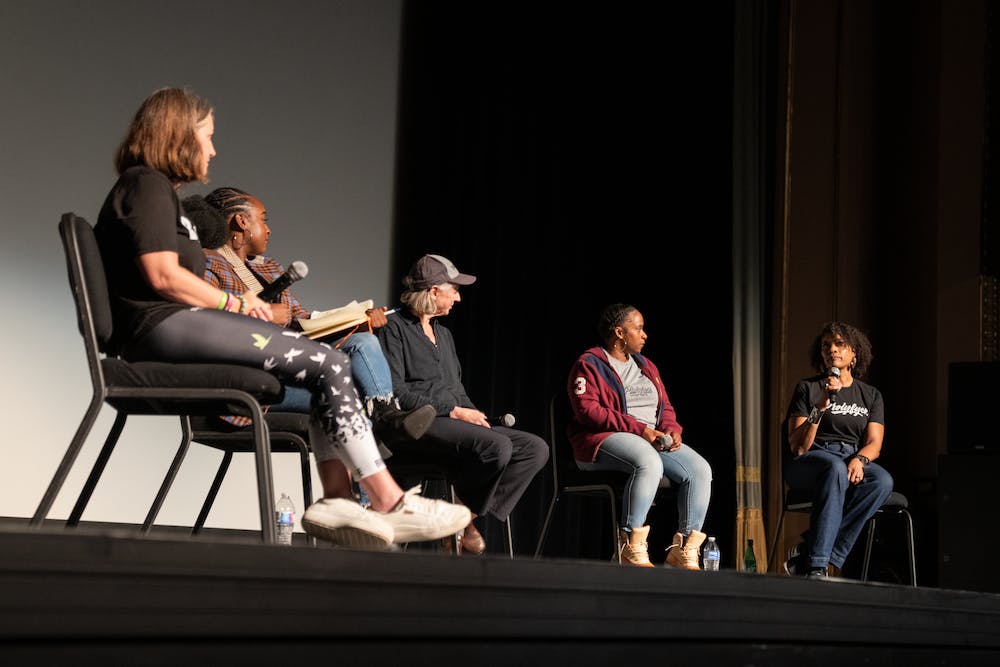 Andrea Lytle Peet, Dr. Peggy Plews-Organ, and members of the Prolyfyck Run Crew sit on a stage with microphones.