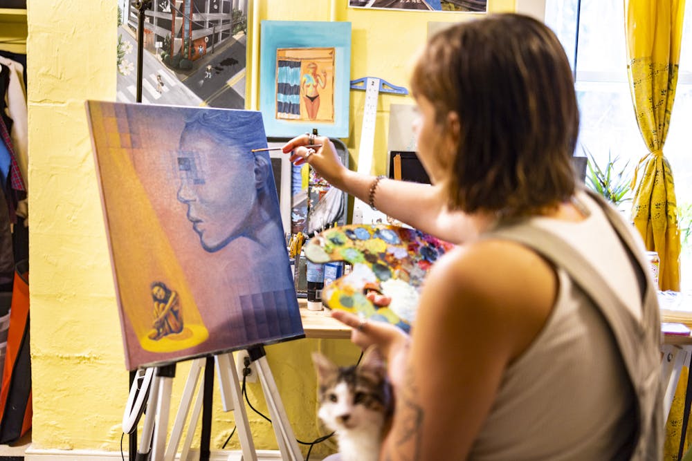 Makaela Johansen paints an orange and purple portrait. 