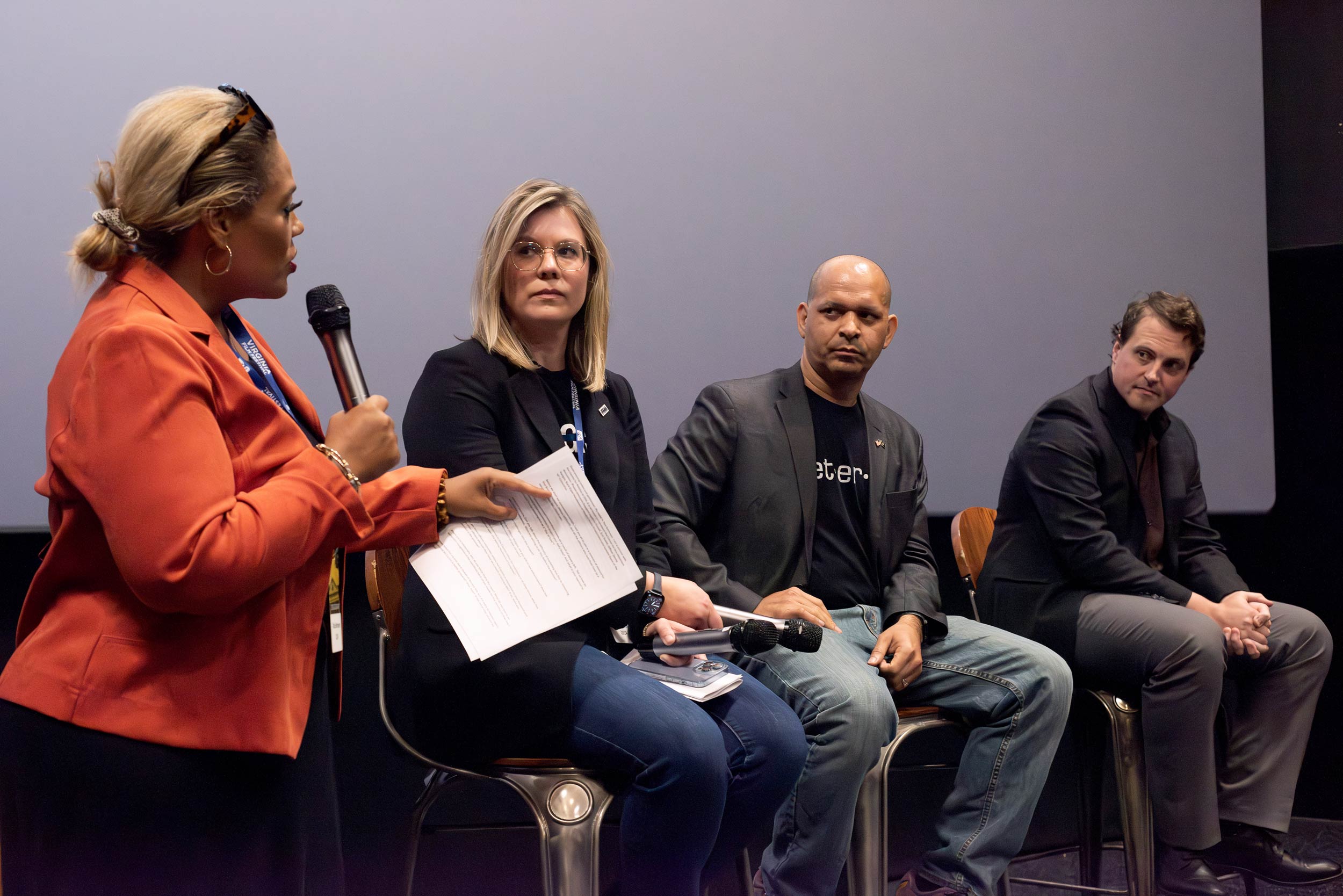 Tara Setmayer stands next to a panel featuring Erin Smith, Aquilino Gonell, and Danny Hodges.