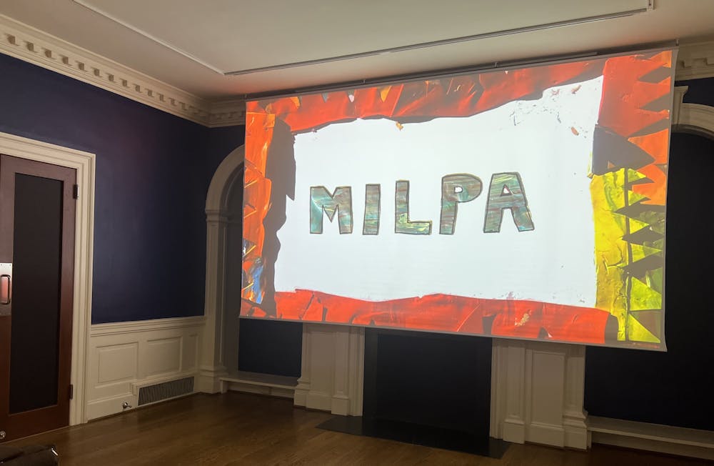 A projector screen hangs in a room with blue walls and reads "MILPA" with a stop-motion border.