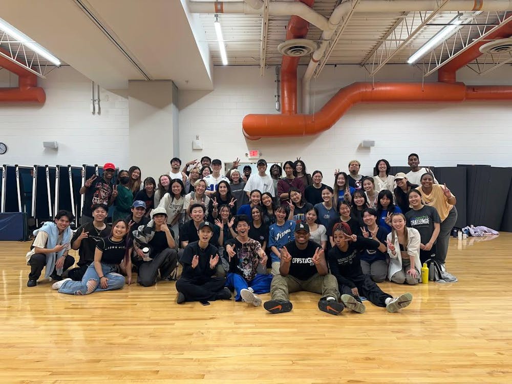 The members of The Mighty smile and pose for a group photo in a gym.