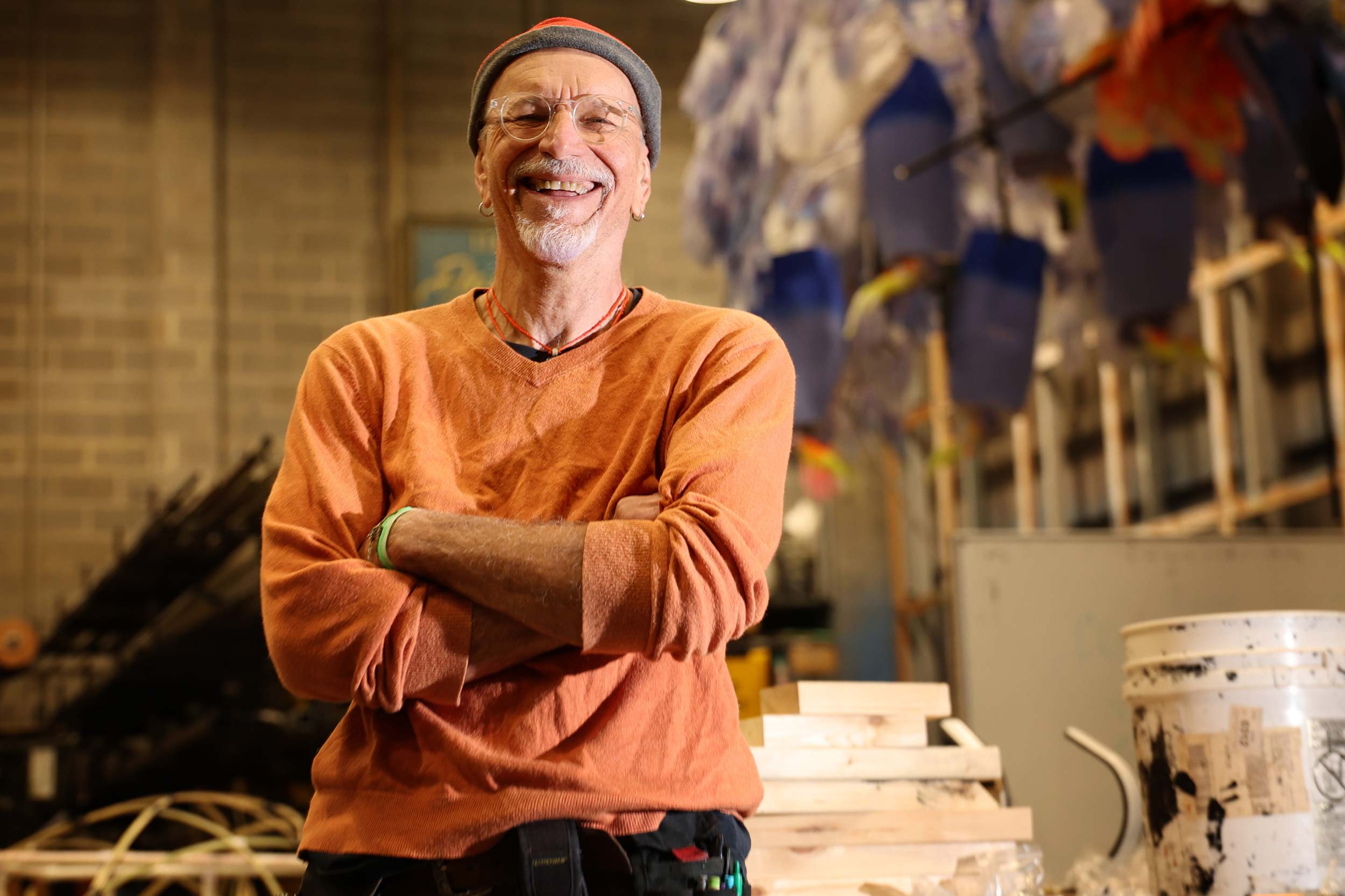 Daniel "Cosmo" Kuzmick standing with his arms crossed and smiling. He is in the UVA Drama Building.