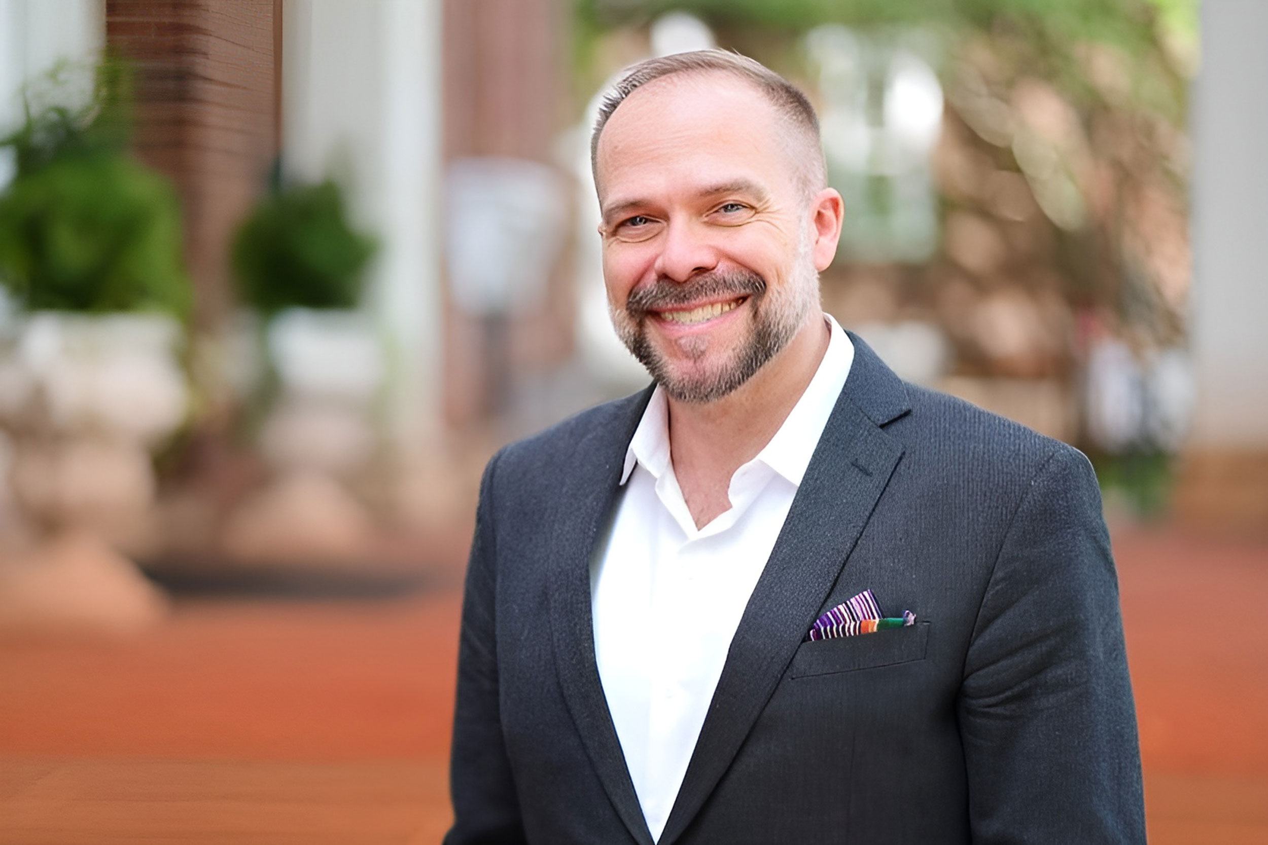 Photo of David. J. Getsy in a suit standing outside infront of a brick building. 