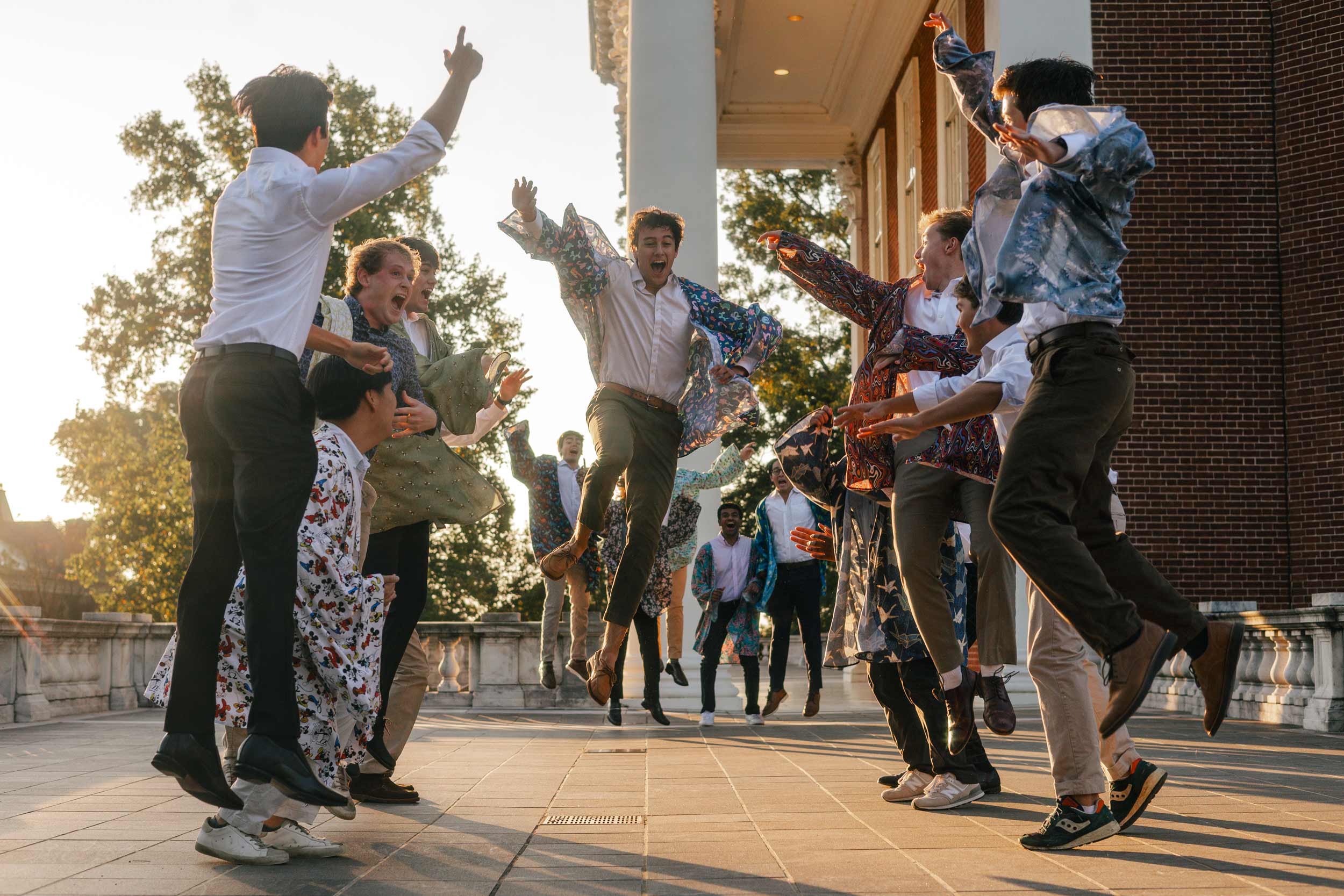 Group of UVA students in the Hullabahoo a-capella group jumping in celebration at the top of the Rotunda.