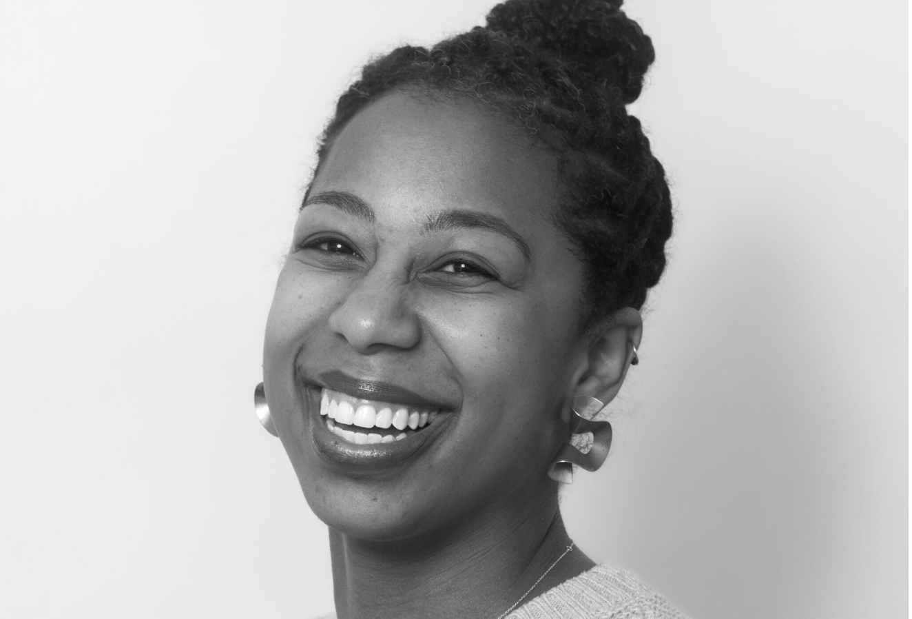 Close up image of Chet'la Sebree smiling at the camera.