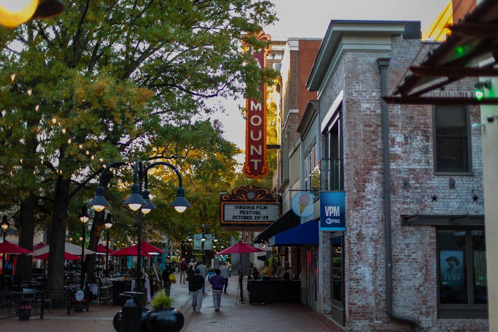 Image of the streets of downtown Charlottesville focusing on the Paramount theatre and the string lights on the downtown mall.