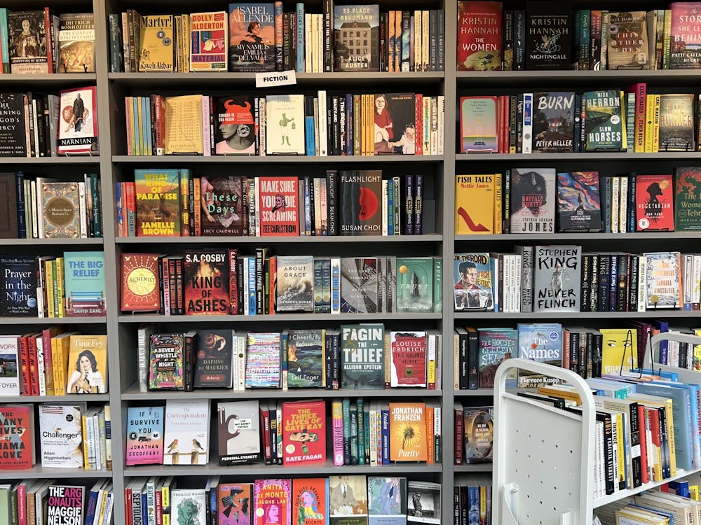 A photo of a floor to ceiling bookshelf filled with various colorful books.