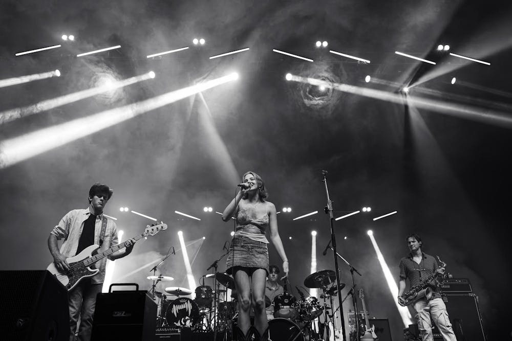 Black and white photo of a large stage at a concert with a college band performing.