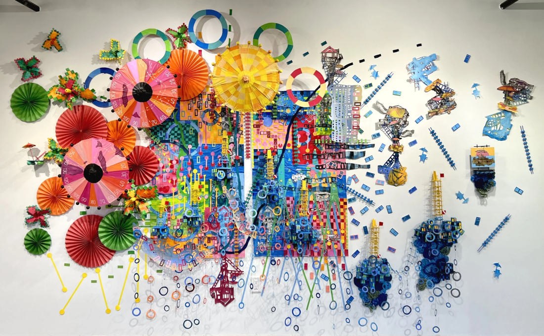 A colorful display of different shapes and paper elements put together in a 3D collage, on a plain white background.