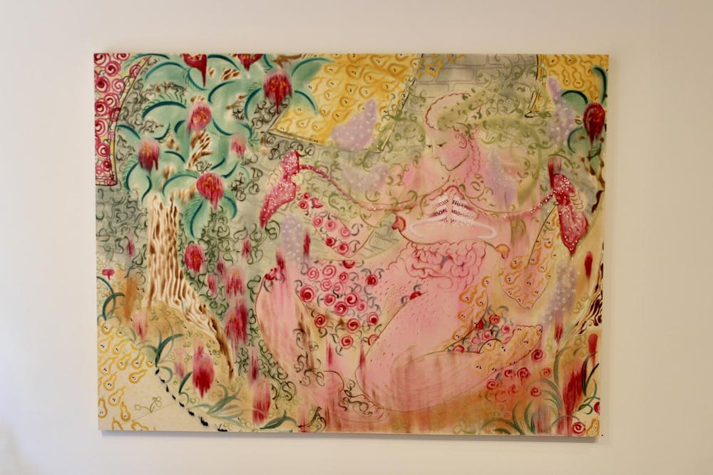 A painting hung on a white wall depicts a human body immersed within a space of colors and shapes, some plantlike and mostly pastel colors.